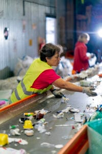 Woman recycling at a facility.